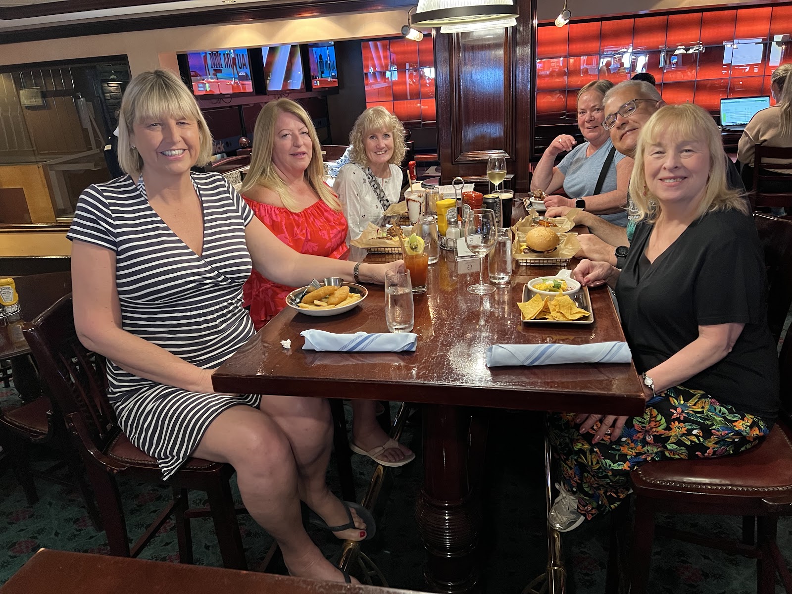 Group of women smiling around a restaurant table with plates of food