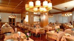 Alpine restaurant dining room with tables set beneath chandeliers