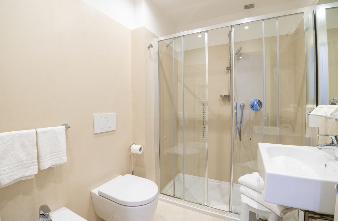 Bathroom with a glass shower cubicle, towels and toilet