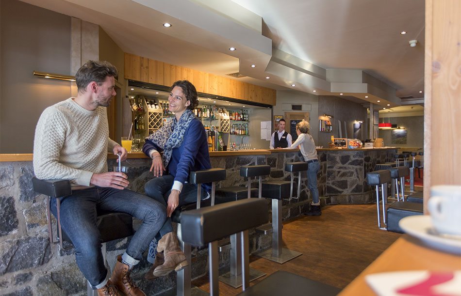 A man and woman chatting over drinks at a bar