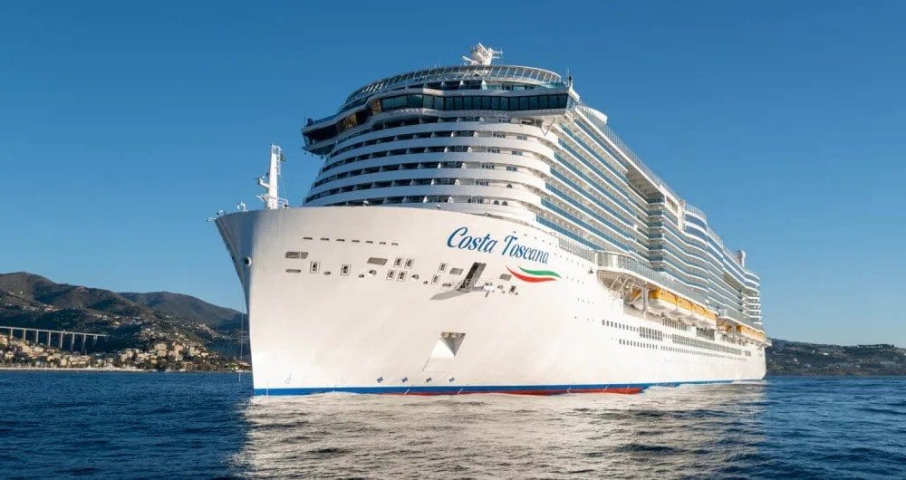 Cruise ship at sea with a coastline behind