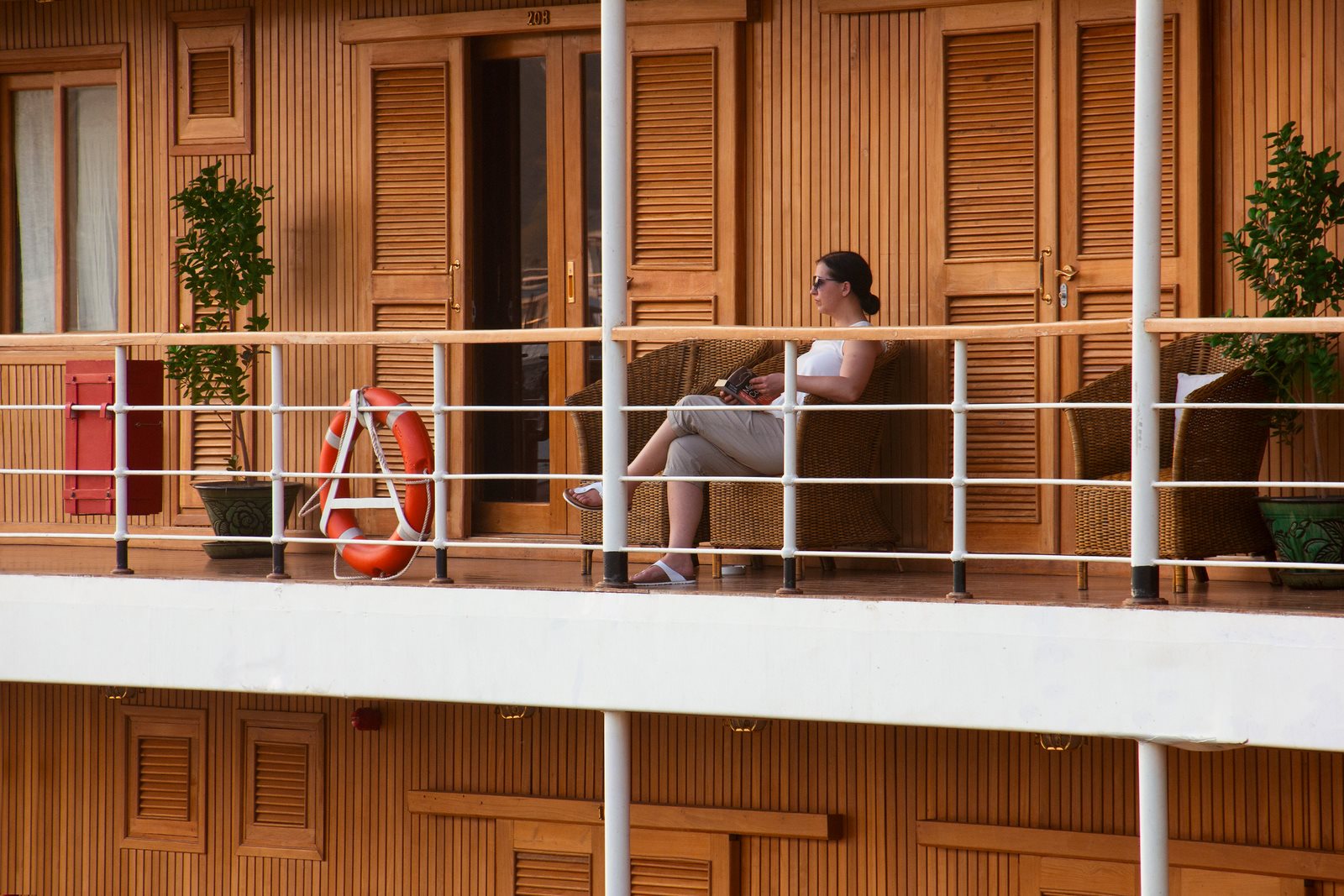 A woman relaxing alone on a private balcony aboard the river cruise boat