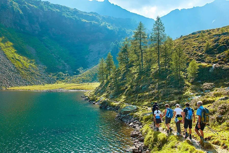 Walkers following a path along the shore of a mountain lake