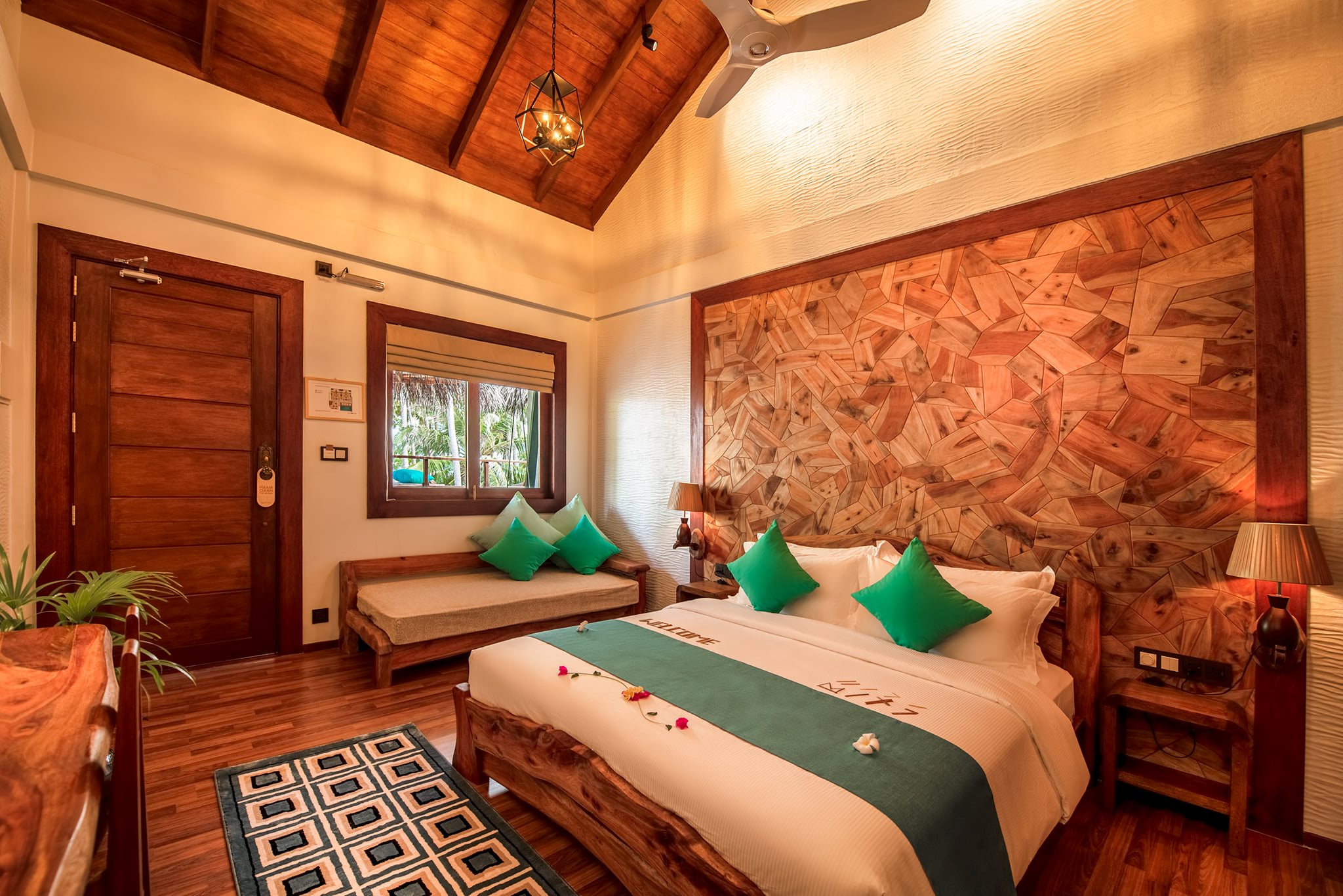 Bedroom with a wood-panelled headboard, green cushions and a daybed
