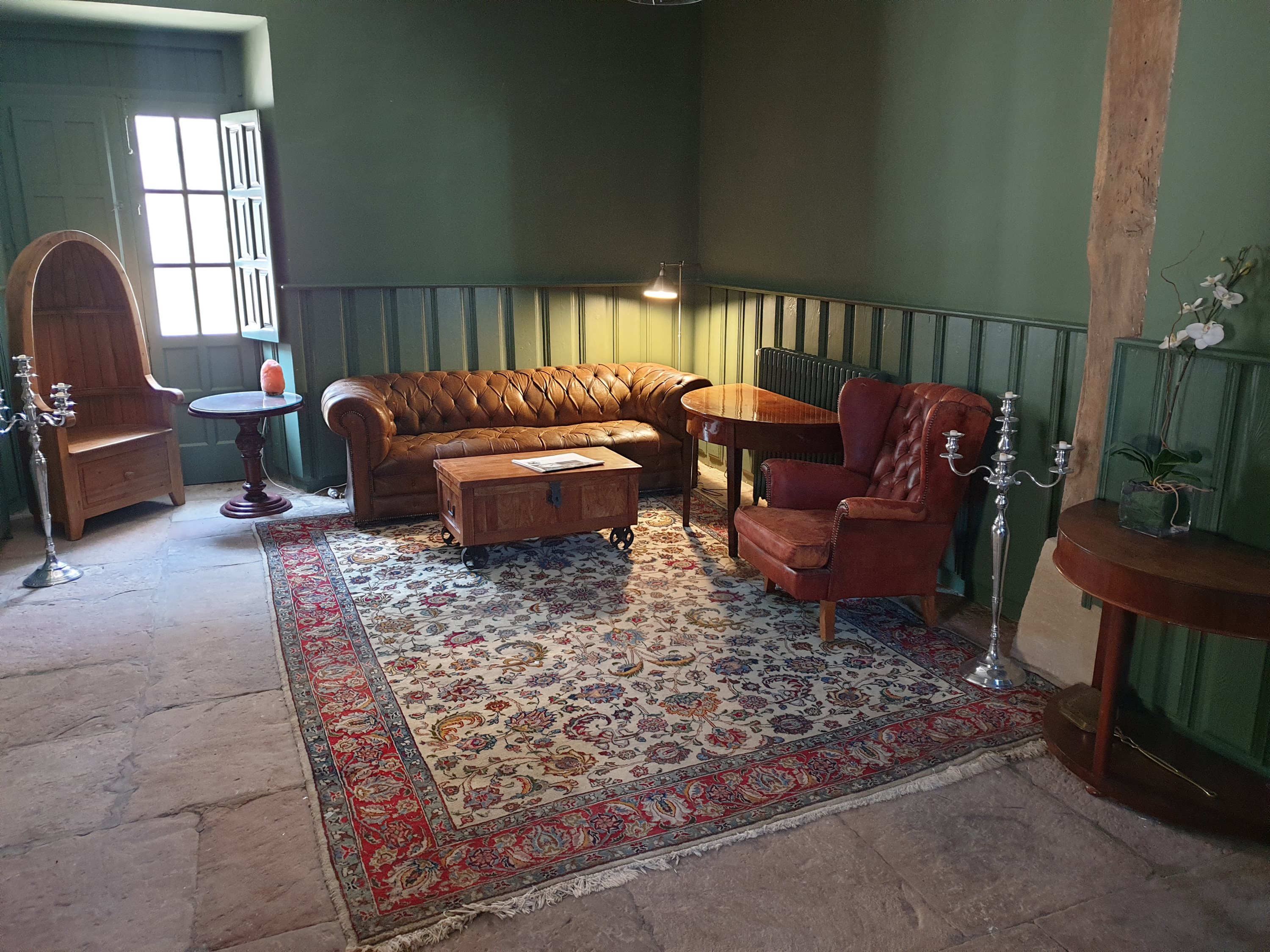 Cosy lounge with a leather Chesterfield sofa and patterned rug
