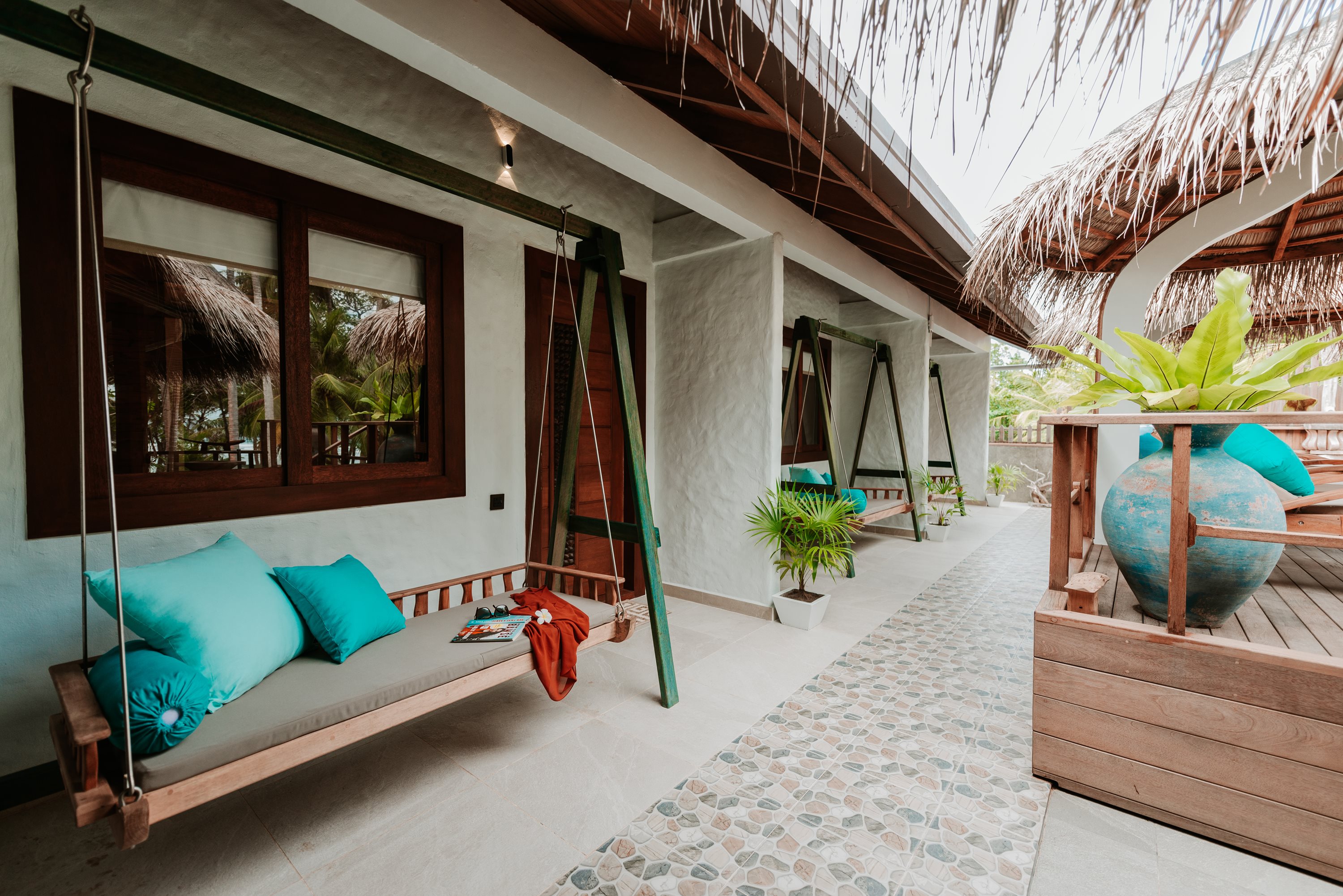 Covered terrace with hanging swing seats and a thatched roof