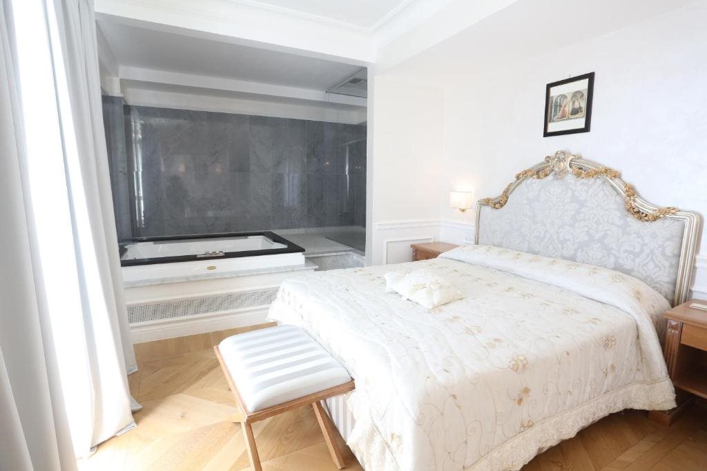 Bedroom with a built-in whirlpool bath and ornate upholstered headboard