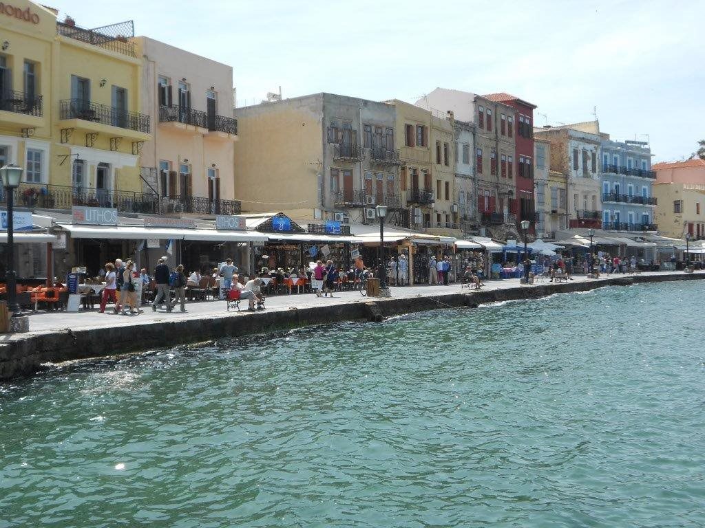 Waterfront promenade lined with colourful buildings and cafes in Chania