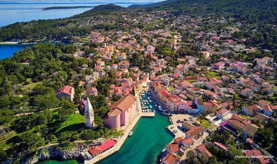 Aerial view of a coastal town with a harbour and church tower