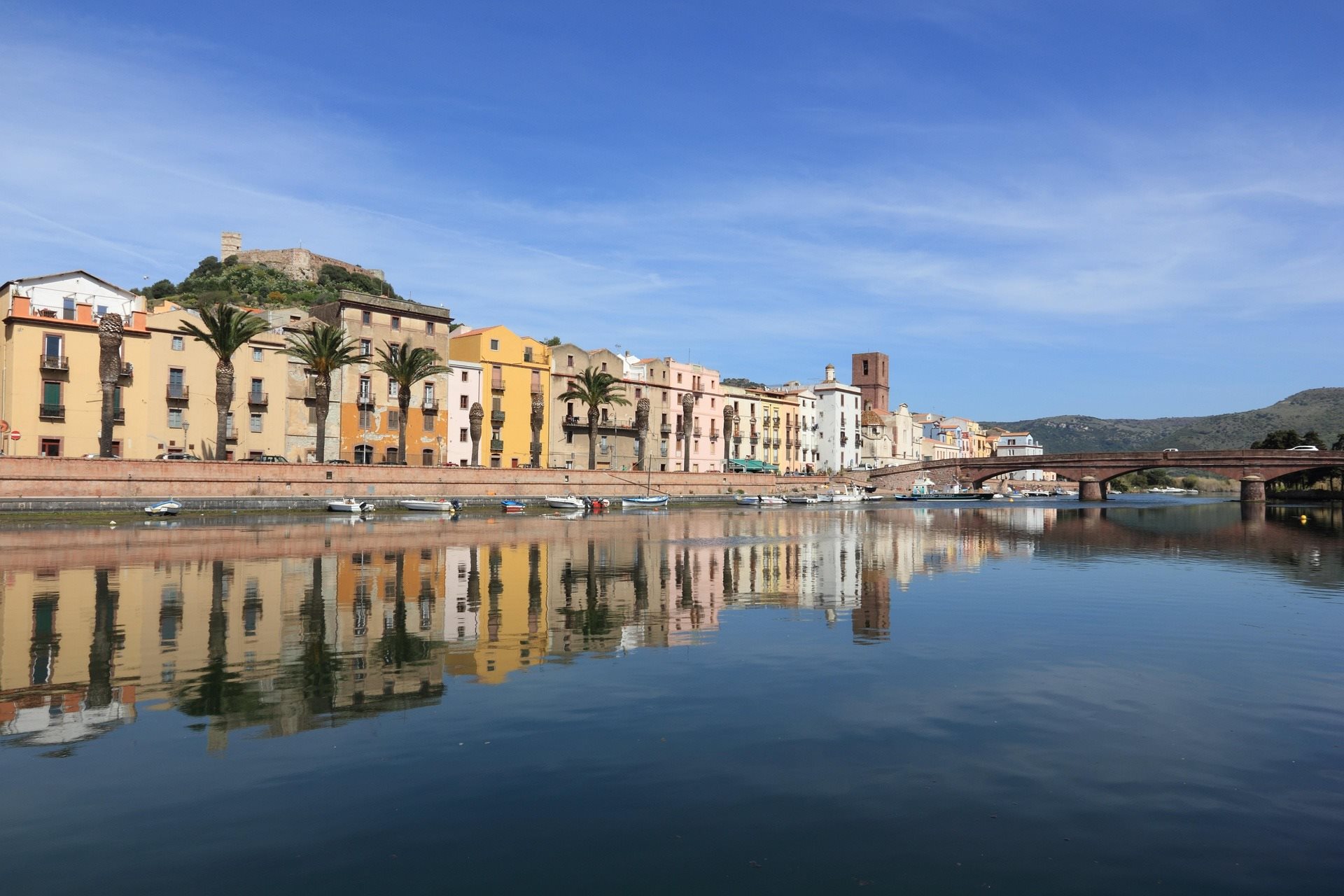 Colourful riverside houses reflected in the water at Bosa
