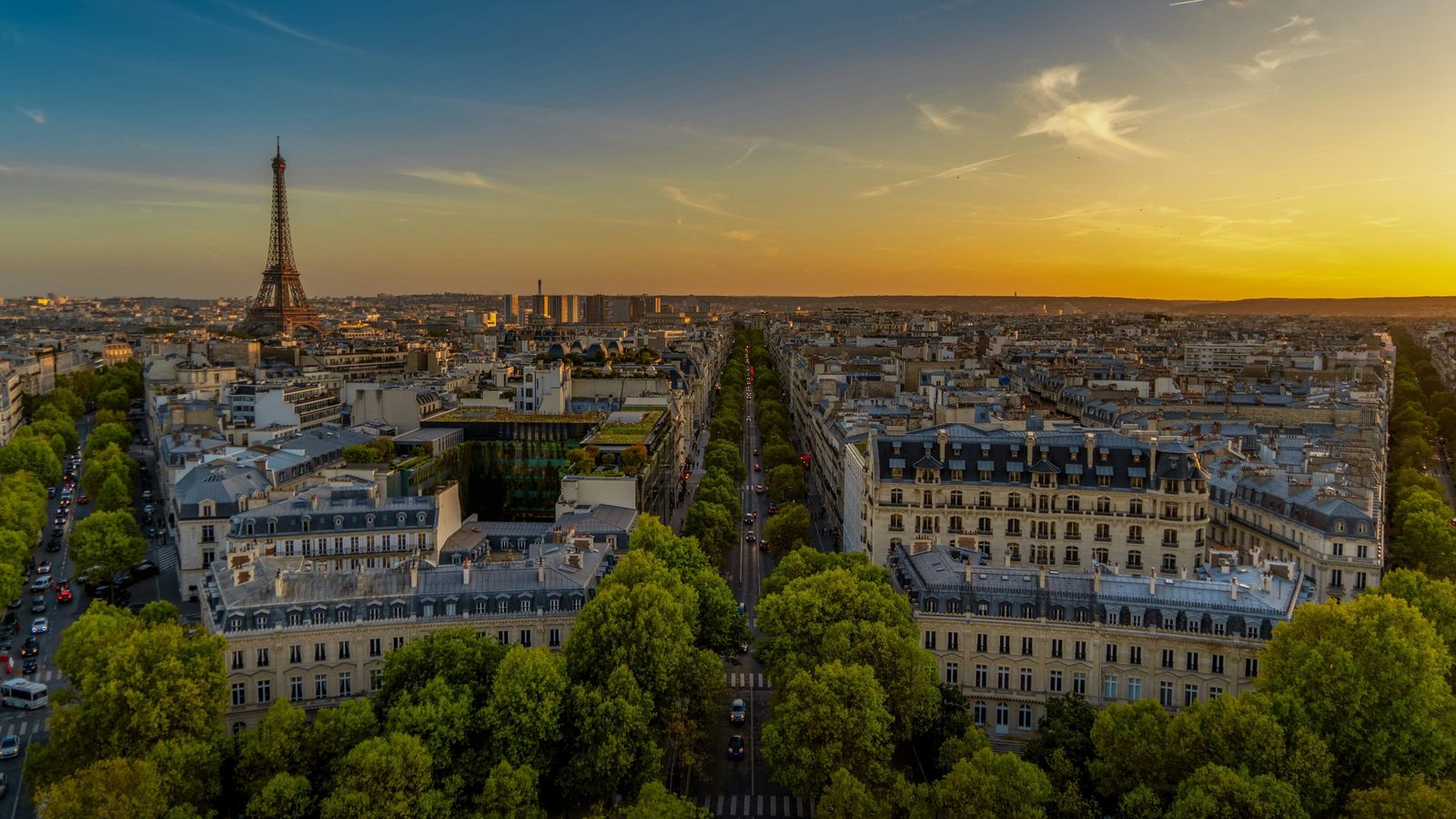 Aerial view of Paris rooftops and the Eiffel Tower at sunset