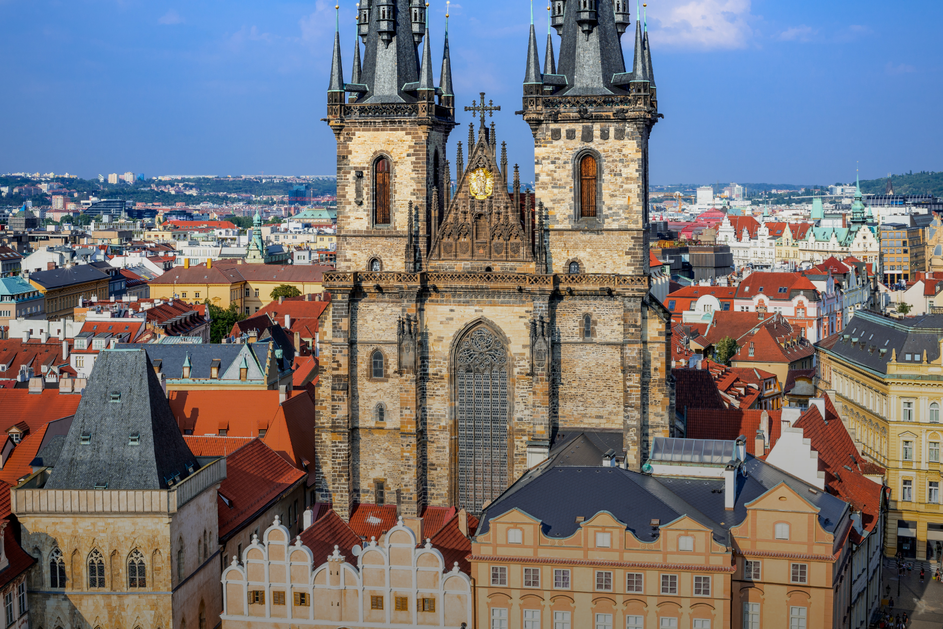 Gothic spires of a church rising above Prague's Old Town rooftops