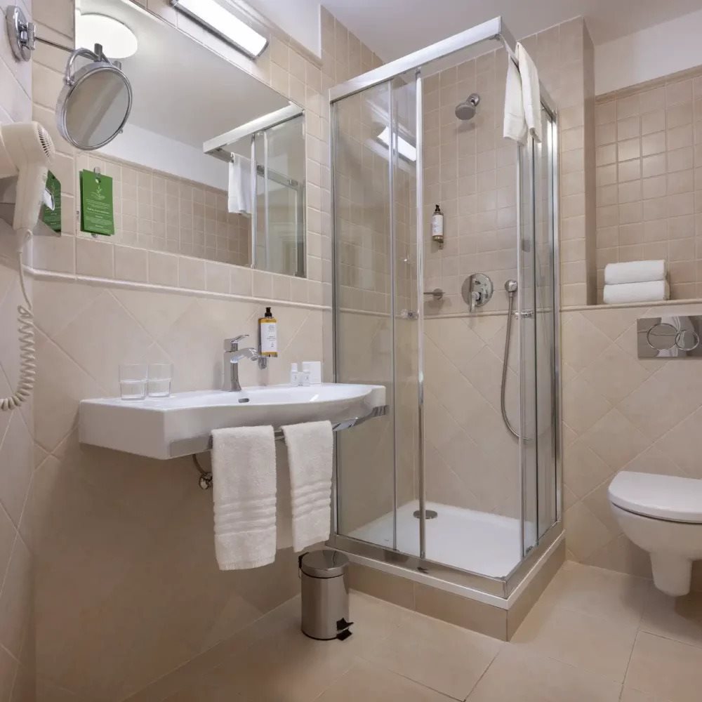 Bathroom with a corner shower cubicle and wall-mounted sink