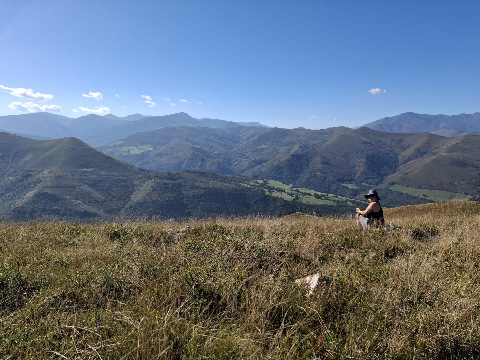 Grassy mountain ridge with a walker looking out over a valley