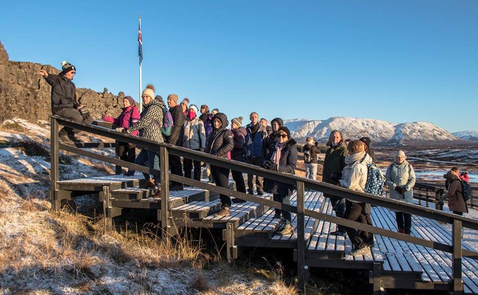 A large Spice group gathered along a wooden viewing walkway, coats and hats on