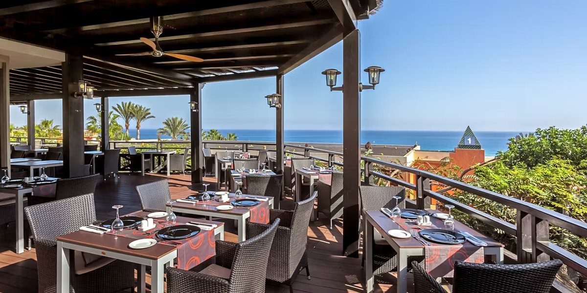 Empty restaurant terrace with a sea view, tables set for dining