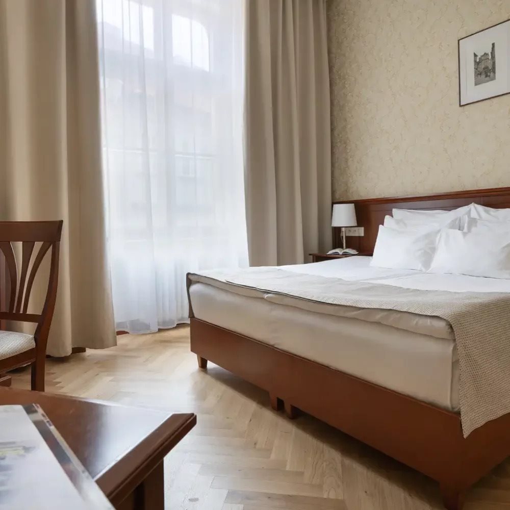 Hotel bedroom with dark wood furniture and net curtains